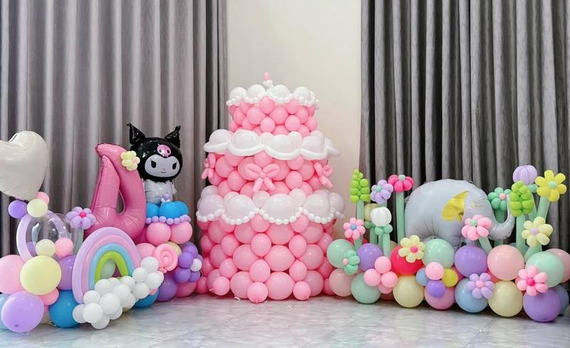 Ảnh trang trí bóng bay sự kiện với sân khấu và backdrop trọn gói gồm bánh kem, các hình thú và hoa màu sắc trang nhã.