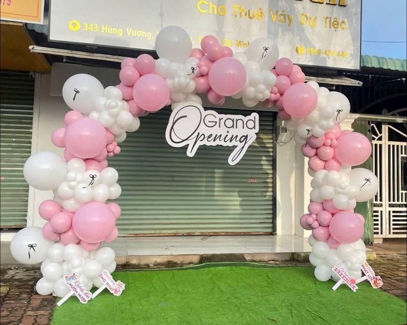 Trang trí bóng bay sự kiện với kiểu dáng vòng cung hồng trắng kết hợp sân khấu và backdrop trọn gói cho khai trương.