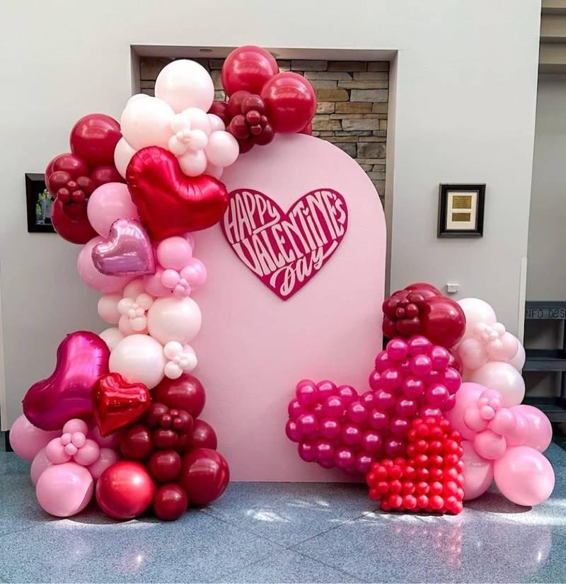 Trang trí bóng bay sự kiện với backdrop trọn gói hình trái tim đỏ hồng tạo điểm nhấn sân khấu ấm áp.