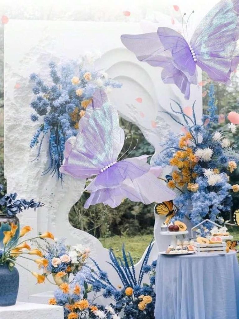 Tiểu cảnh trang trí ngày phụ nữ công ty với backdrop 8/3 và 20/10 kết hợp hoa, bướm tím, phù hợp văn phòng.