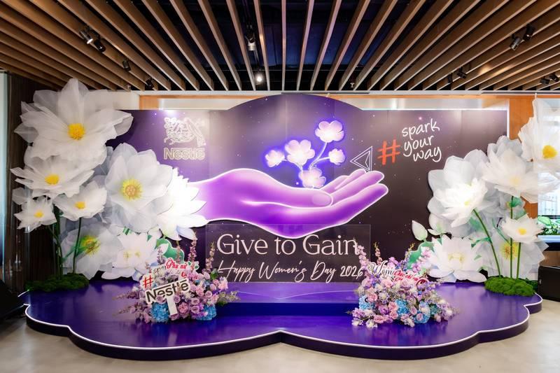 Tiểu cảnh trang trí ngày phụ nữ công ty với backdrop 8/3 và hoa lớn tạo không gian sang trọng cho văn phòng.