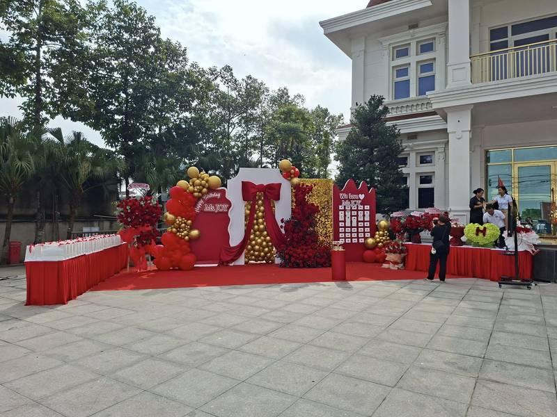 Trang trí sân khấu sự kiện với thiết kế và thi công trọn gói HCM tông đỏ và vàng sang trọng ngoài trời.