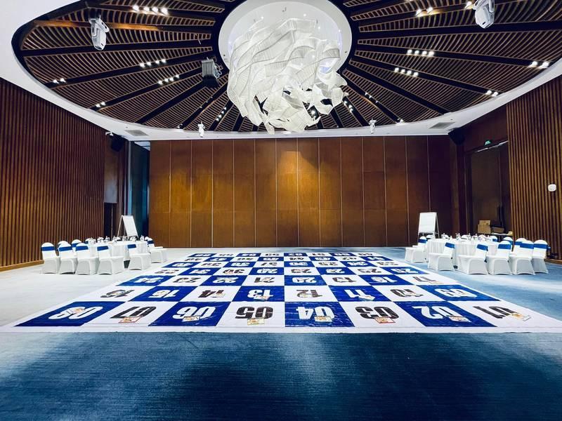 Ảnh trang trí sân khấu sự kiện với thiết kế và thi công trọn gói HCM, không gian hội trường rộng rãi và bàn ghế bố trí chuyên nghiệp.